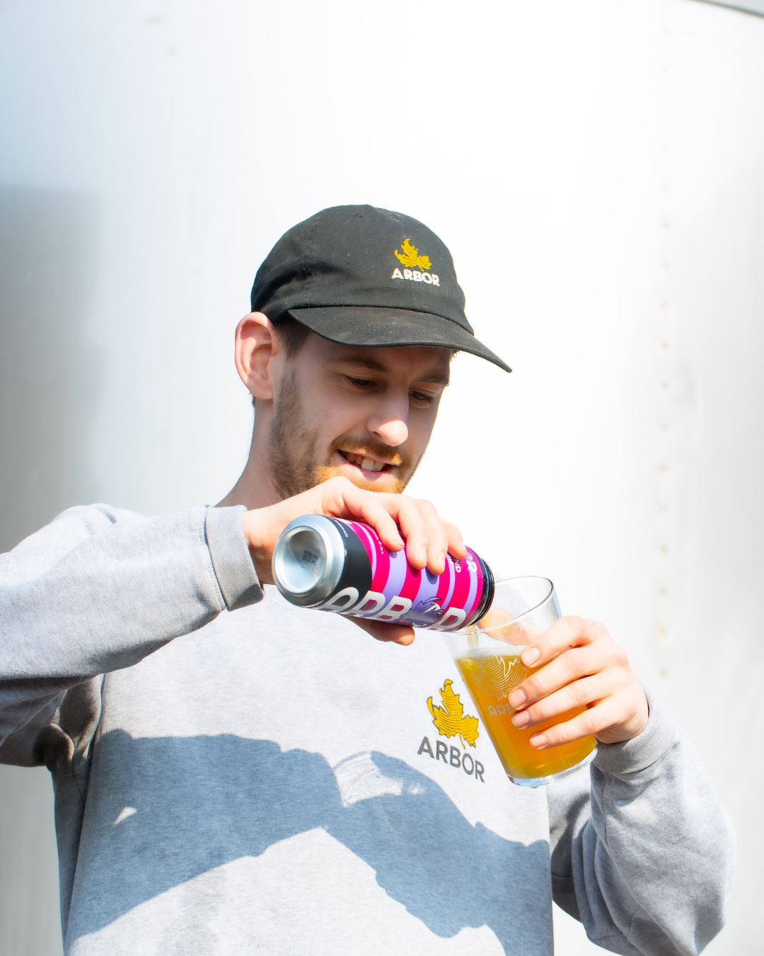 An Arbor Ales brewer pouring a pint can of craft beer into a glass outside the Bristol brewery