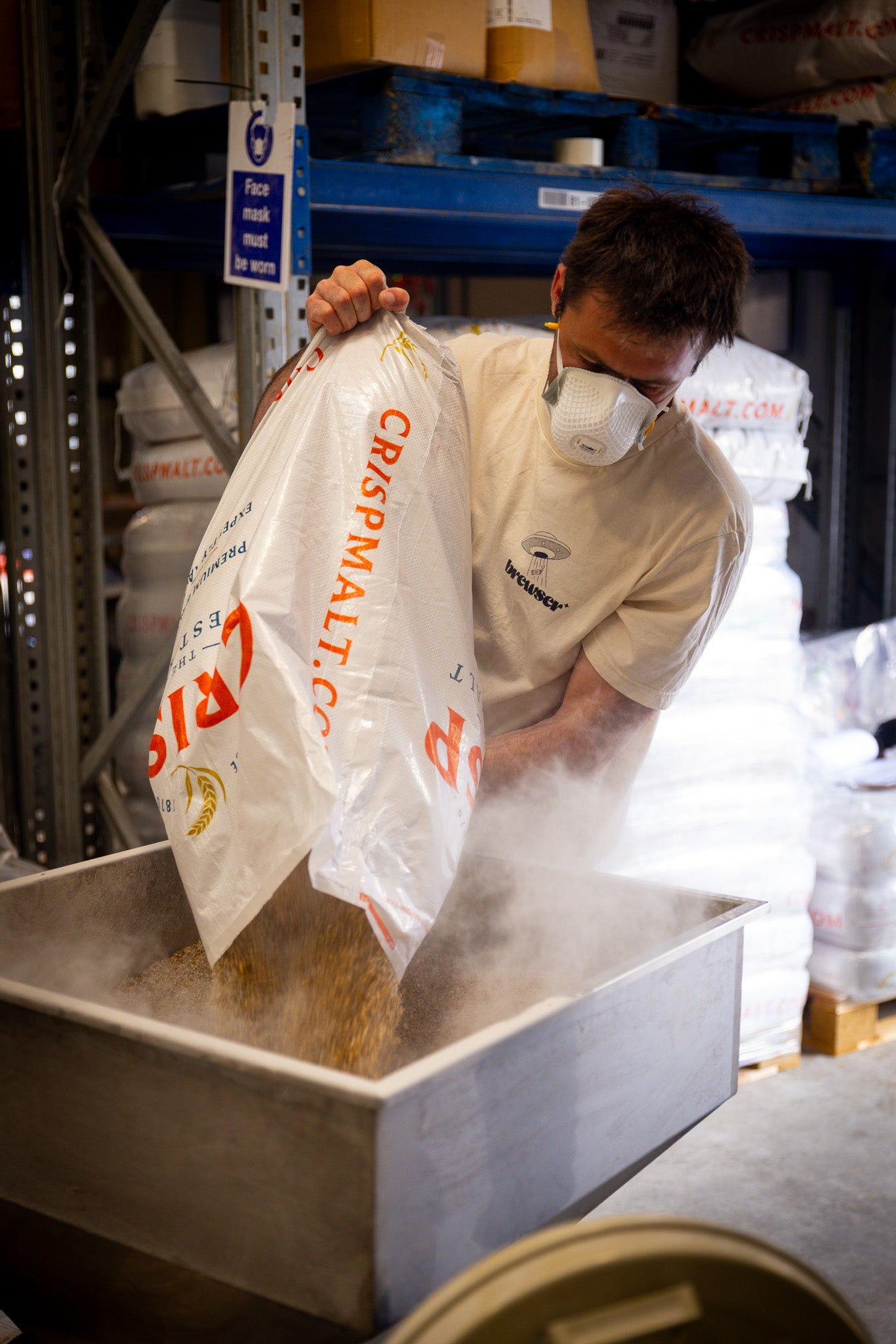 Brewer pouring Crisp Malt grain into a mash tun, behind the scenes of the Brewser craft beer subscription