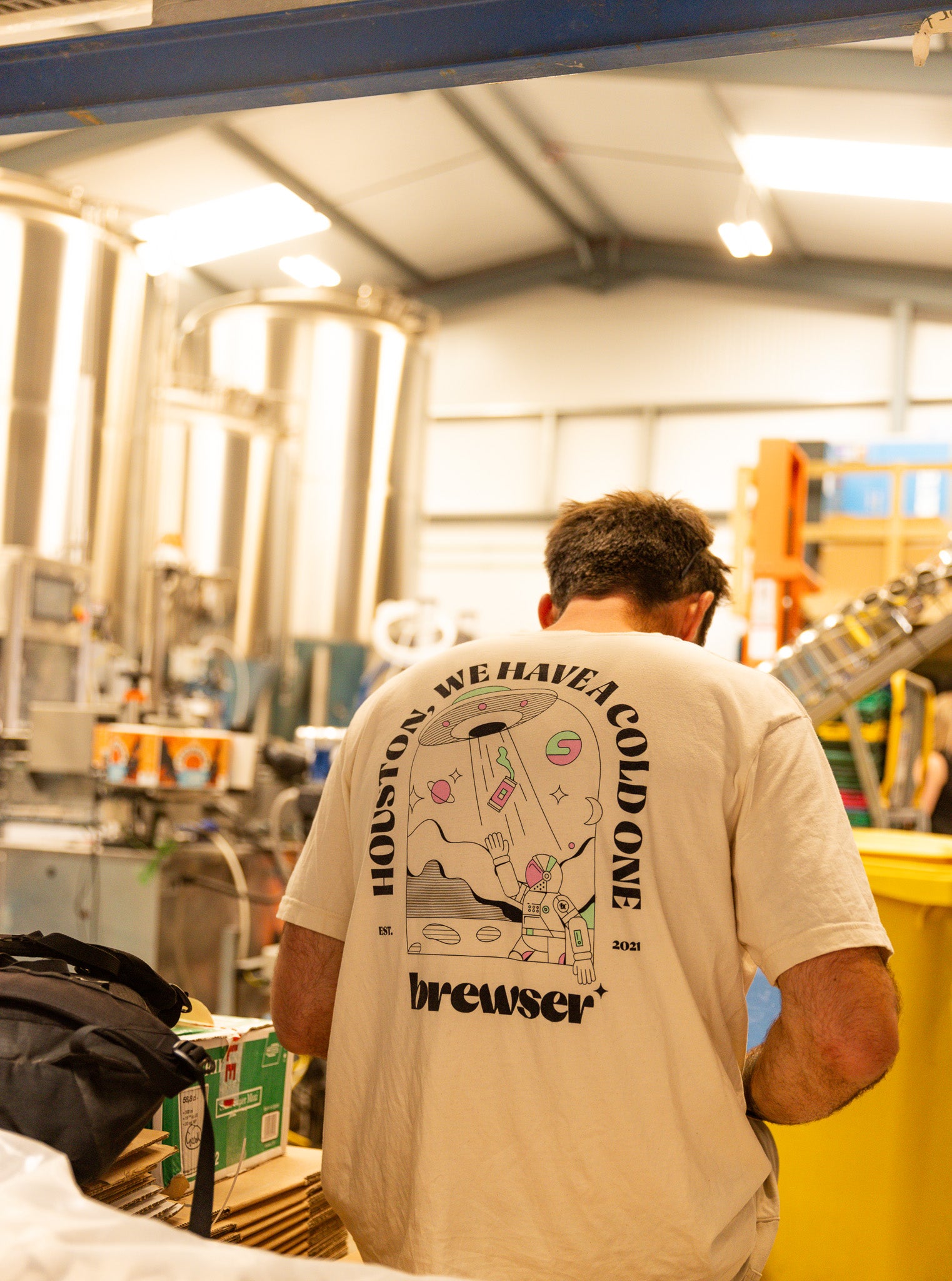 Person in a Brewser 'Houston we have a cold one' t-shirt at a brewery, behind the scenes of the Brewser subscription