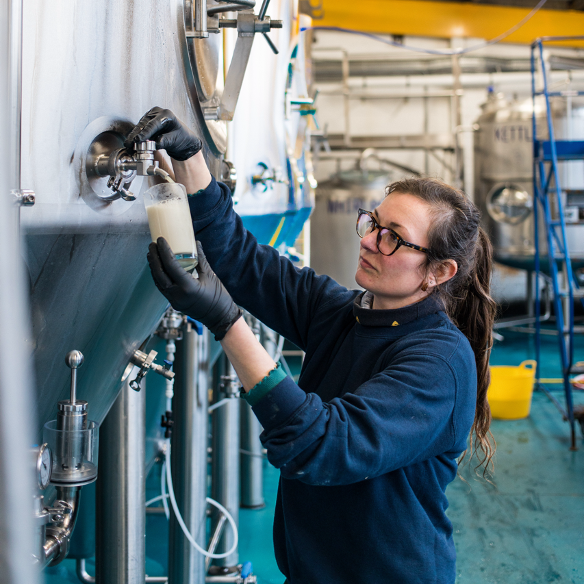 Brewer taking a sample from a tank at Brewing Brothers, a Brewser craft beer subscription partner brewery