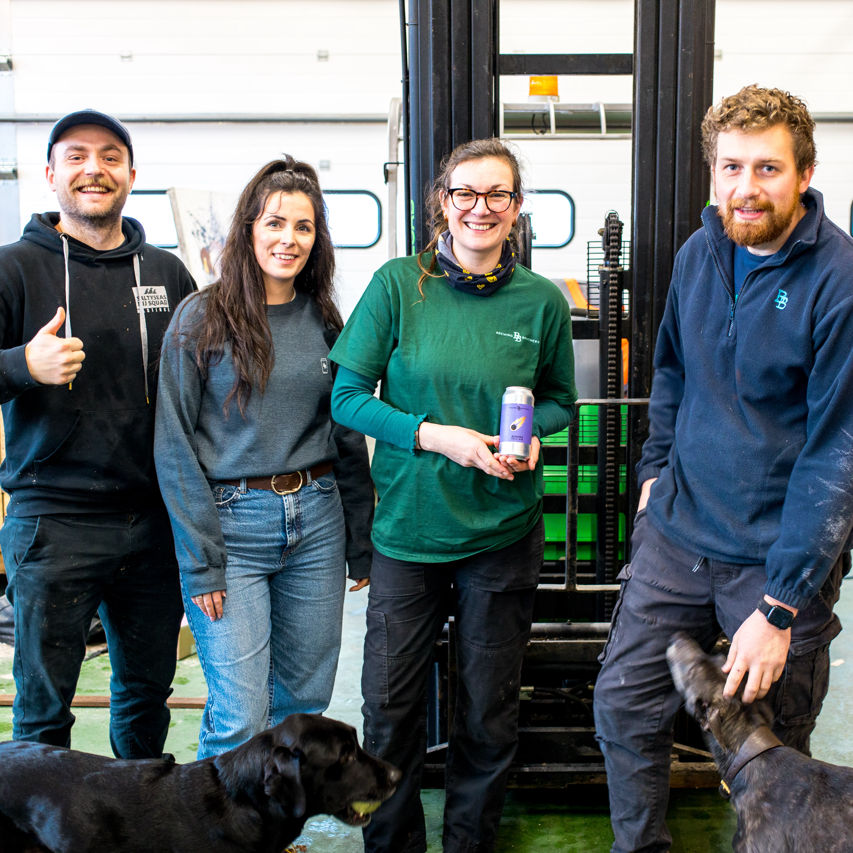 Brewing Brothers team with two dogs in the brewery holding a can, a Brewser craft beer subscription partner