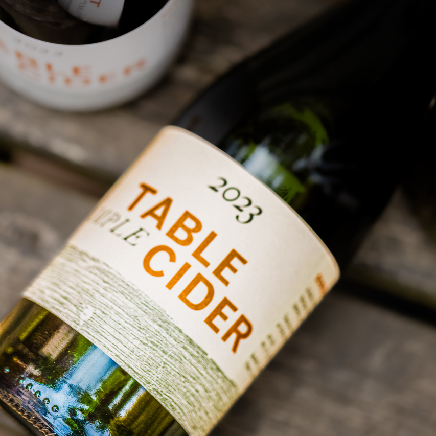2023 Table Cider bottle close-up on rustic wood, part of a Brewser craft beer and cider subscription