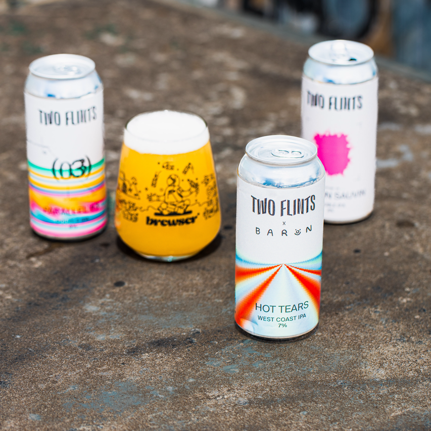 Two Flints Brewery cans including Hot Tears West Coast IPA beside a Brewser glass, craft beer subscription
