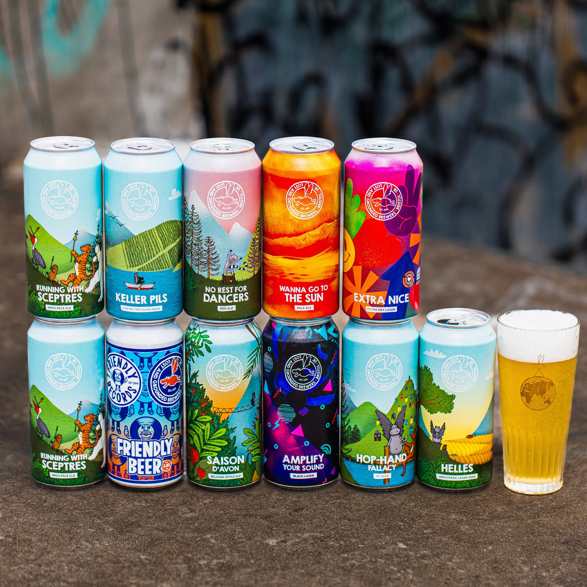 Lost and Grounded Brewers full can range standing with a poured lager, Brewser craft beer subscription box