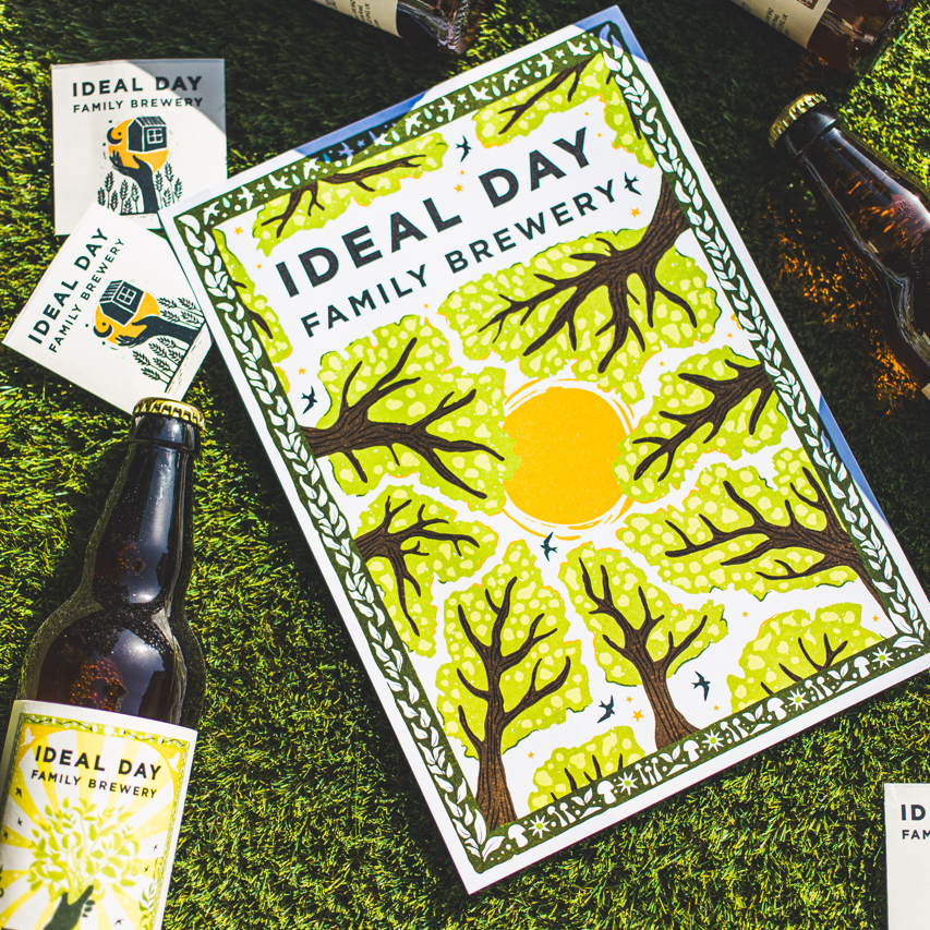 Ideal Day Family Brewery branded print, cards and beer bottles laid on grass, Brewser craft beer subscription