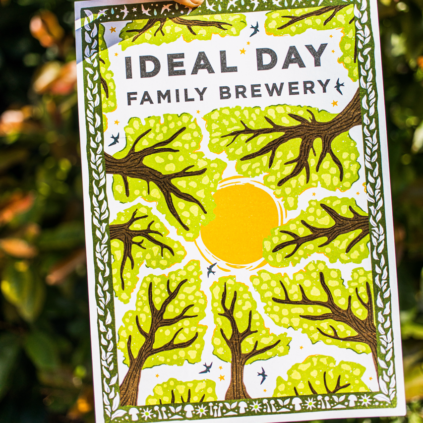 Ideal Day Family Brewery illustrated card held up close against greenery, Brewser craft beer subscription