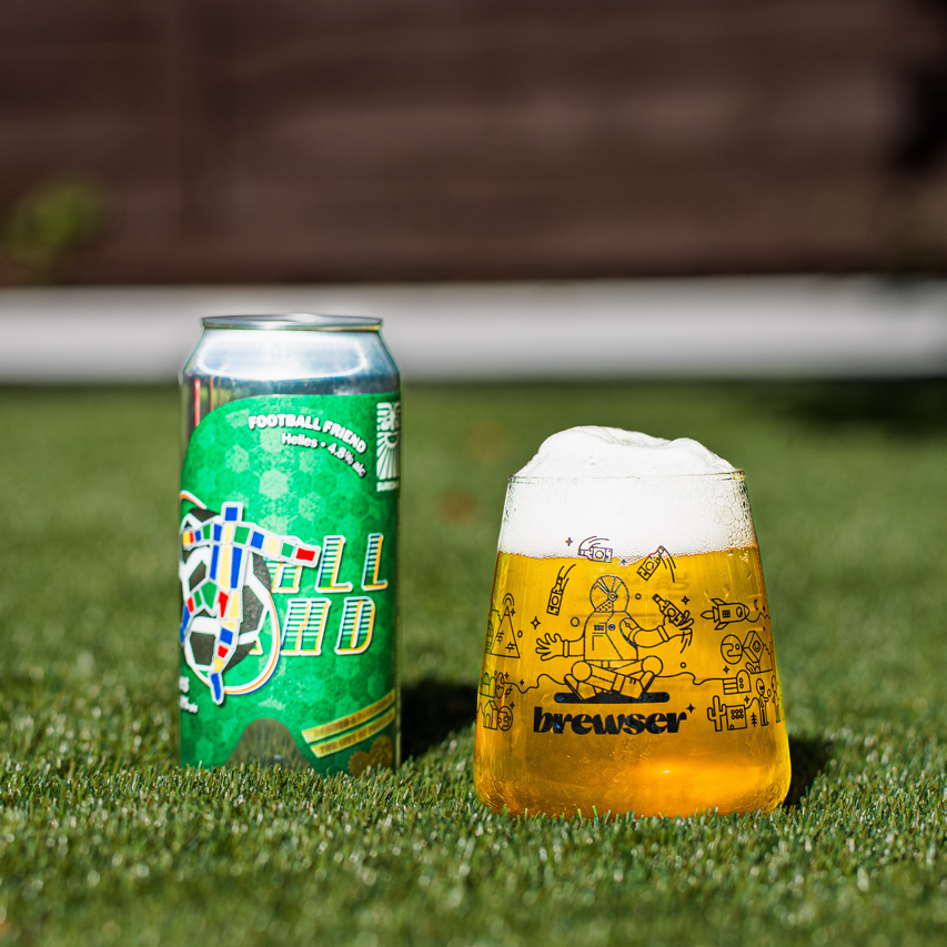 Sureshot Brewing Football Friend Helles can with a poured Brewser glass on grass, craft beer subscription
