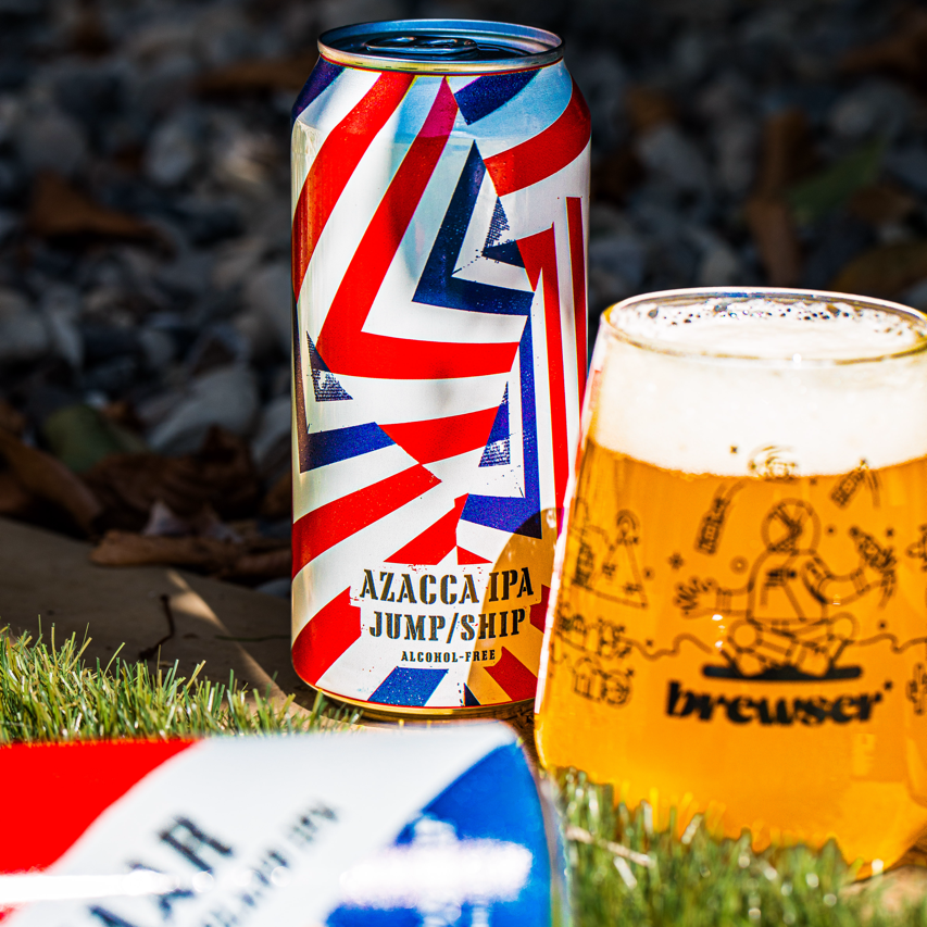 Jump Ship Brewing Azacca alcohol-free IPA can with a poured Brewser glass on grass, craft beer subscription