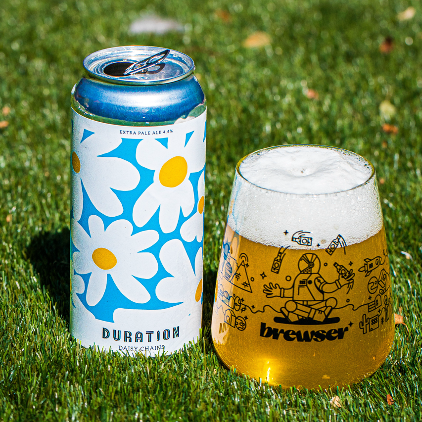 Duration Brewing Daisy Chains Extra Pale Ale can with a poured Brewser glass on grass, craft beer subscription