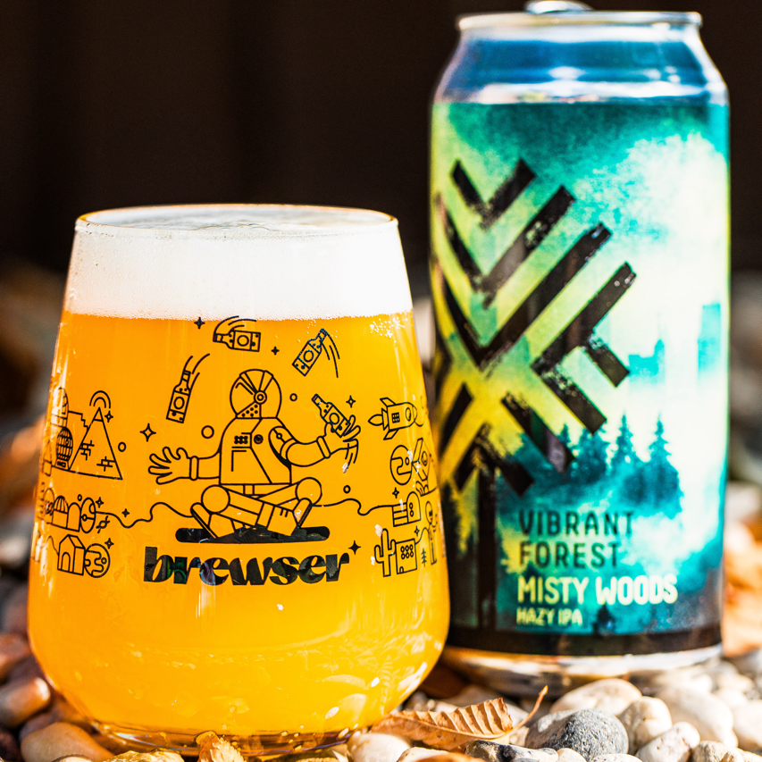 Vibrant Forest Misty Woods Hazy IPA can with a poured Brewser glass on pebbles, craft beer subscription