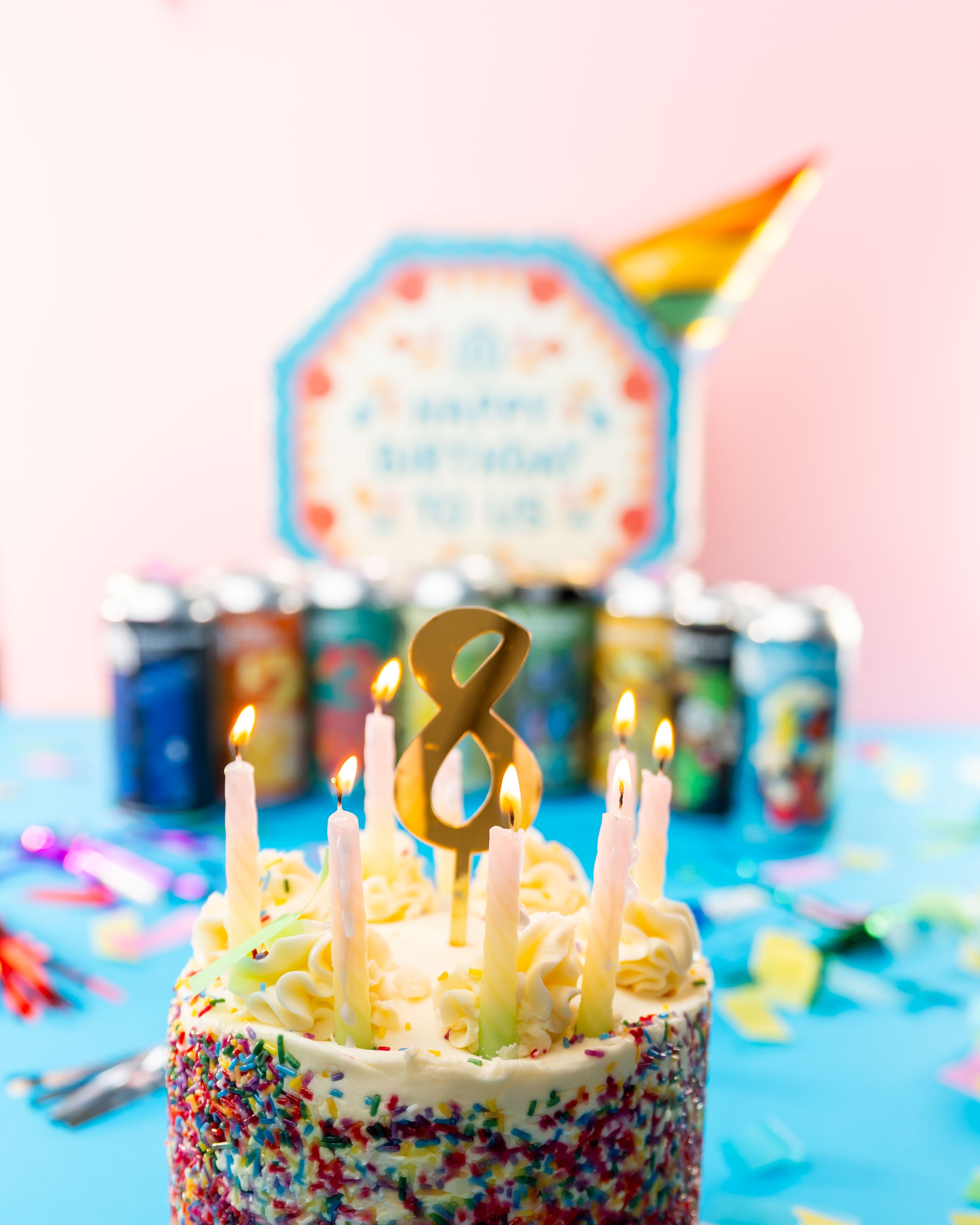 Brewser 8th birthday cake with a gold 8 candle and assorted craft beer cans, celebrating the Brewser subscription box