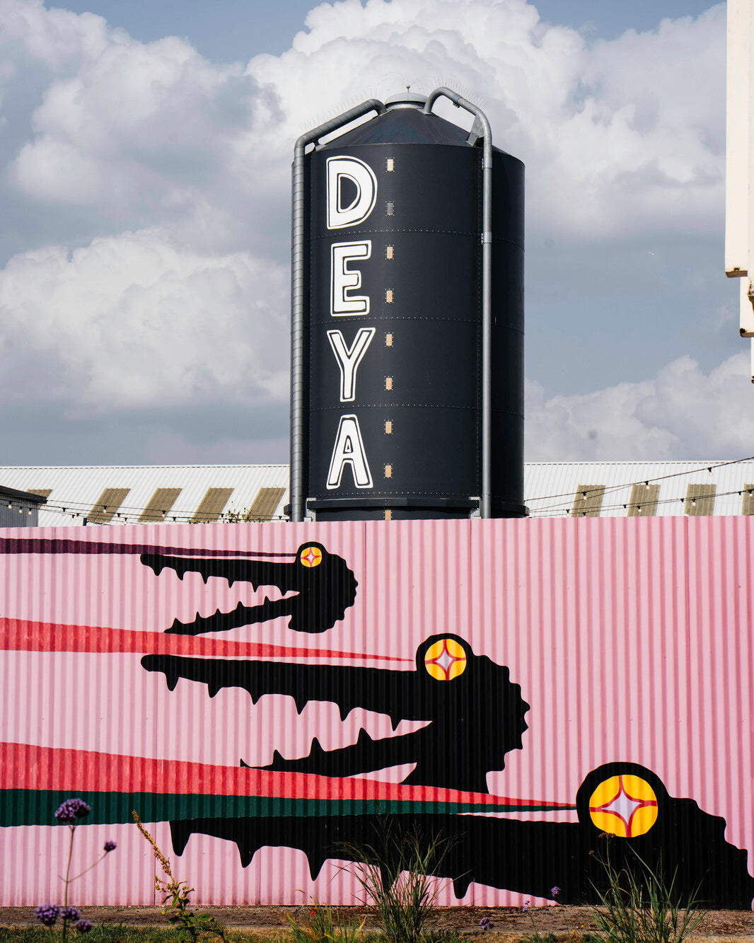 DEYA Brewing Company black silo exterior with crocodile mural art against a cloudy blue sky - Brewser craft beer subscription box sources beer direct from brewery UK