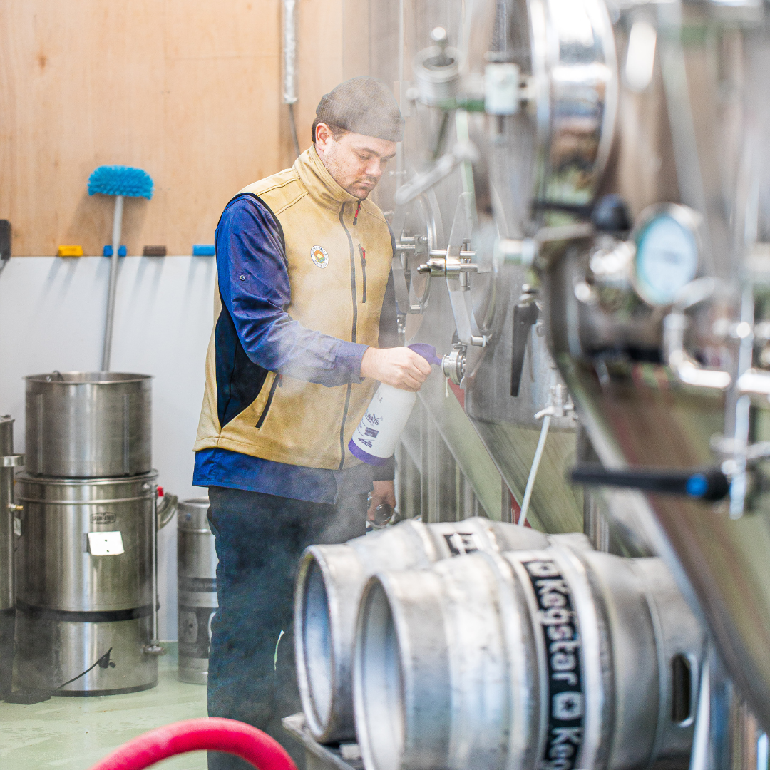 Brewer working at fermentation tanks and kegs inside a craft brewery, Brewser subscription box